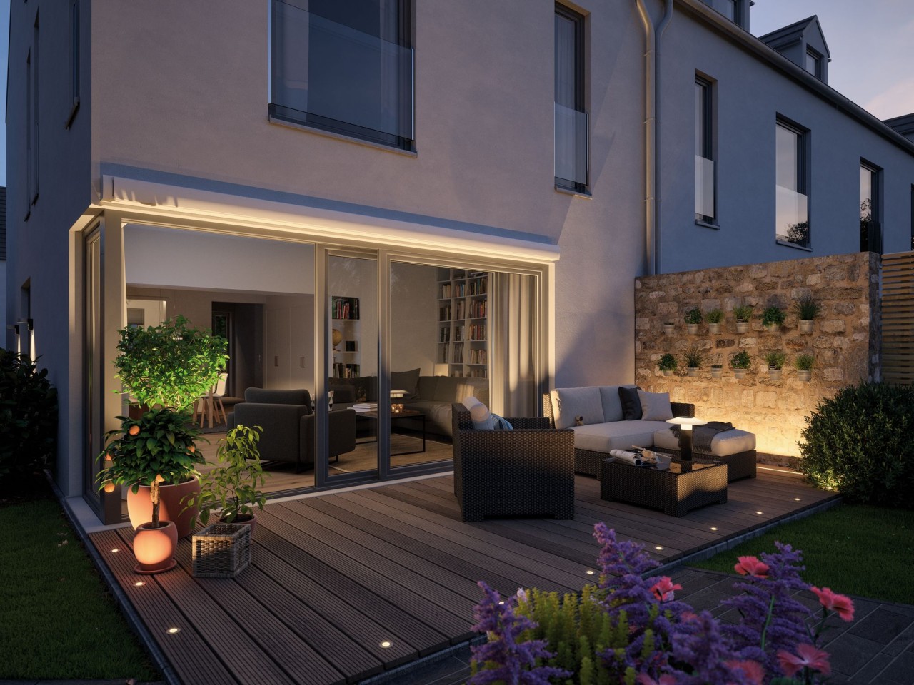 Moderne Terrasse mit gemütlichen Sitzmöbeln und Pflanzen bei Abenddämmerung