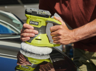 Eine Person poliert ein Auto mit einer grünen Ryobi-Poliermaschine