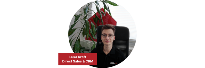 Eine Person sitzt auf einem Bürostuhl vor einer Pflanze und einem Fenster