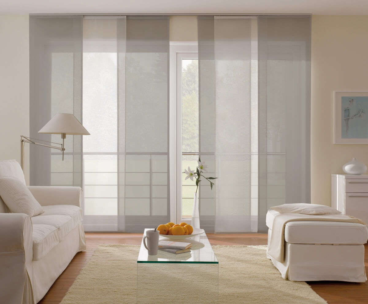 Helles Wohnzimmer mit weißen Möbeln und großen Fenstern