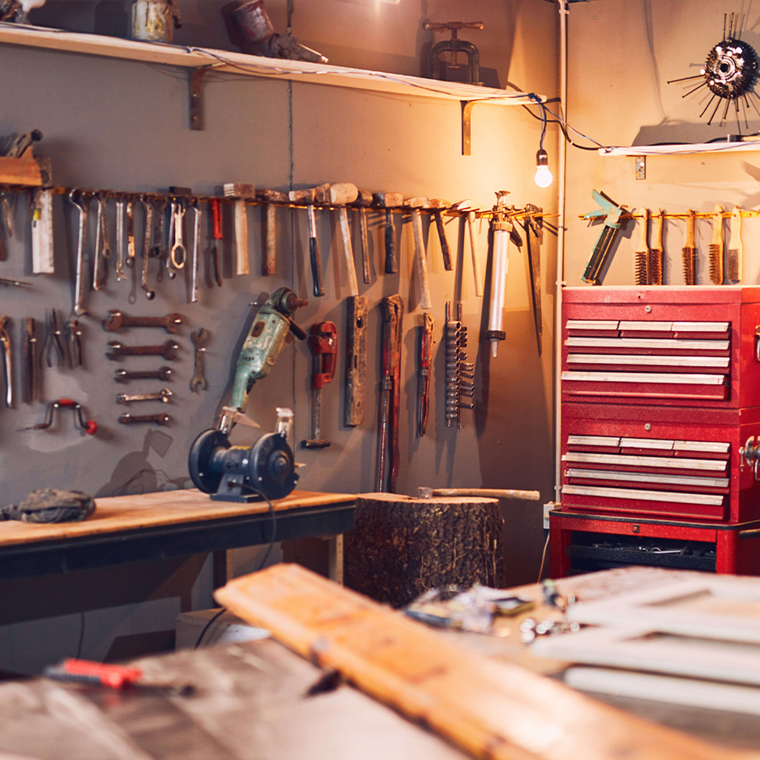 Eine Werkstatt mit Werkzeugen an der Wand und einem roten Werkzeugschrank