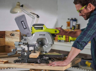 Ein Mann benutzt eine Kappsäge, um ein Holzstück zu schneiden