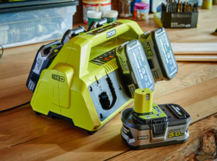 Ladegerät mit mehreren Akkus auf einem Holztisch